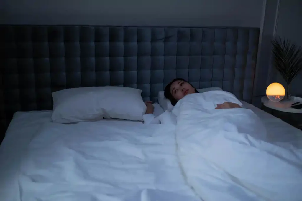 불면증을 해결하고픈 여성이 침대에 누워있는 모습
